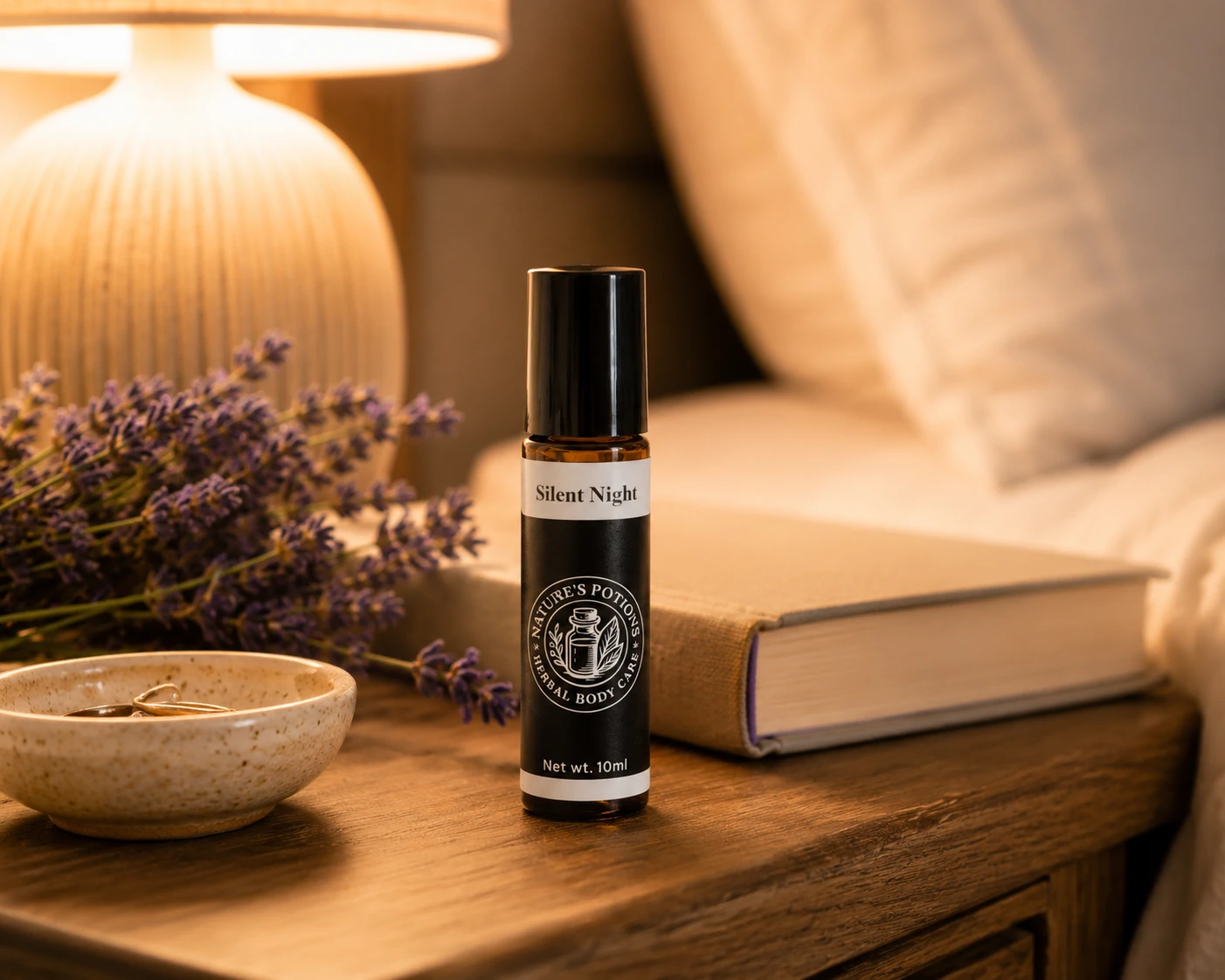 Book, low lamp, tea, and a Nature’s Potions aromatherapy roller in an evening setting